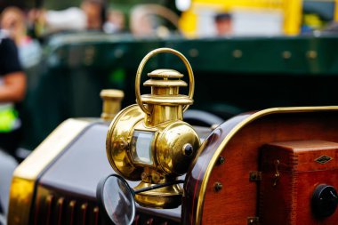 Velden, Avusturya - 30 Ağustos 2025: Pirinç ve ahşap kaplamalı klasik araçların sergilendiği bir Eski Zaman Festivali 'nde işçiliği ön plana çıkaran klasik araba lambası