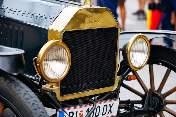 Velden, Avusturya - 30 Ağustos 2025: Klasik Ford arabası, festival atmosferiyle çevrili pirinç aksanlar ve yuvarlak farlar da dahil olmak üzere klasik tasarım unsurlarını ön plana çıkarıyor