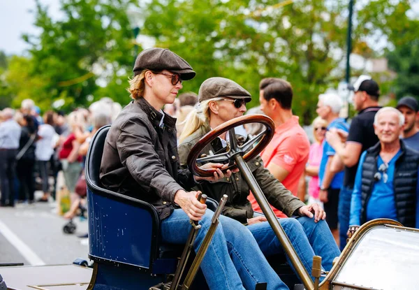 Velden, Avusturya - 30 Ağustos 2025: Antika araba severler Oldtimer Festivali 'nde coşkulu bir kalabalığın coşkulu atmosferinin tadını çıkardıkları klasik bir araç kullanıyorlar