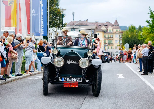 Velden, Avusturya - 30 Ağustos 2025: Klasik Cadillac klasik otomobiller ve şenlikli ambiyansı takdir eden seyirci kalabalığıyla Eski Zaman Festivali 'nden geçiyor