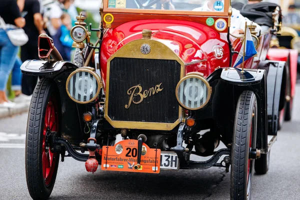Velden, Avusturya - 30 Ağustos 2025: Oldtimer Festivali 'nde klasik tasarımı ve coşkulu izleyicilerle çevrili canlı renklerini vurgulayan klasik Benz arabası sergileniyor