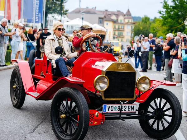 Velden, Avusturya - 30 Ağustos 2025: Vintage Ford Model T otomobili, Oldtimer Festivali 'nde turluyor, canlı bir kalabalık arasında klasik tasarımını ve canlı kırmızı rengini vurguluyor