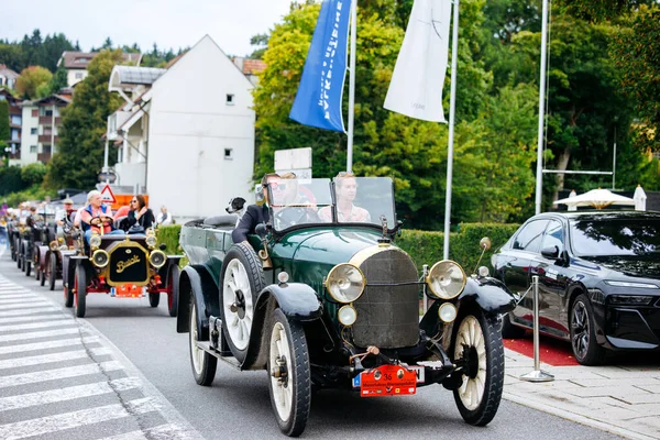 Velden, Avusturya - 30 Ağustos 2025: Eski Zaman Festivali sırasında klasik klasik arabalar cadde boyunca ilerlerken, seyirciler güzel otomobillere hayran kaldılar