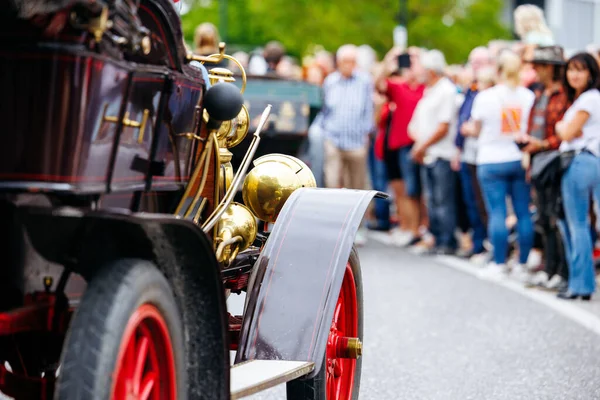 Velden, Avusturya - 30 Ağustos 2025: Antika araba, Oldtimer Festivali 'nde pirinç aksanlı ve kırmızı tekerleklerle klasik araçlara hayran kalabalıklar