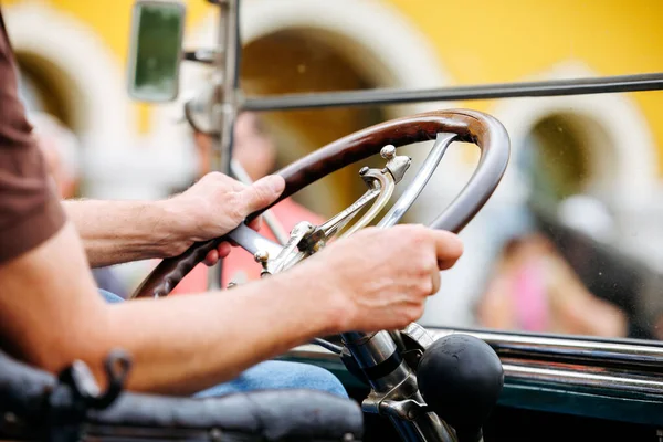 Velden, Avusturya - 30 Ağustos 2025: Eski Zaman Festivali 'nde klasik direksiyonun elleri klasik direksiyonu, işçiliği ve otomotiv mirasının neşesini ön plana çıkarıyor