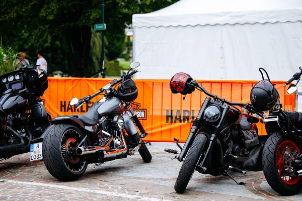 Velden, Avusturya - 30 Ağustos 2025: Harley-Davidson motosikletleri turuncu bir bariyerin yanında park edilmiş, motosiklet kültürü ve toplum kültürünün özünü yakalıyorlar