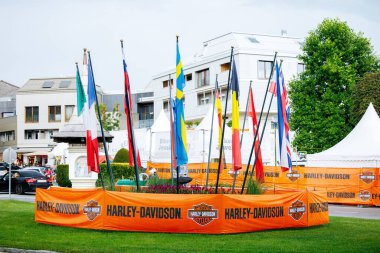 Velden, Avusturya - 30 Ağustos 2025: Farklı ulusları temsil eden bayraklı Harley-Davidson etkinliği, şenlikli bir ortam yarattı ve motosiklet kültürü ve toplum kültürünü ön plana çıkardı