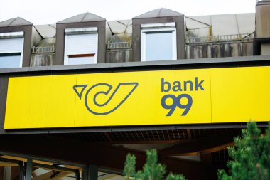 Velden, Avusturya - 30 Ağustos 2025: Banka 99 tabelası markanın modern estetik ve canlı renk düzenini vurgulayan çağdaş bir yapı cephesinde yer almaktadır