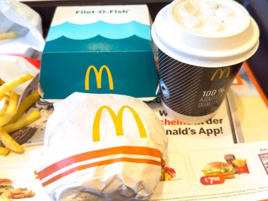 Villach, Avusturya - 11 Ocak 2026: McDonald 's Fileto-O-Fish sandviçi, kahve ve kızartmaları bir masada, fast food kültürü ve canlı sunumu içermektedir