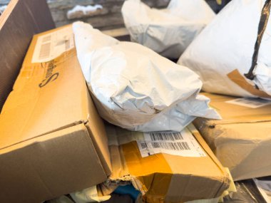 Villach, Avusturya - 12 Ocak 2026: Çeşitli karton kutular ve paketler bir araya getirilerek çevrimiçi alışveriş teslimatları ve lojistiğin yoğun doğasını vurguladı