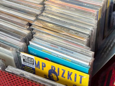 Villach, Avusturya - 12 Ocak 2026: Çeşitli sanatçı ve türlerin yer aldığı kırmızı bir sepette müzik CD 'lerinin gösterimi