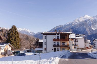 Cortina, İtalya - 27 Ocak 2026: Dolomitler 'de balkonları olan karlı evler, dağlarla çevrili ve kışın açık mavi gökyüzü