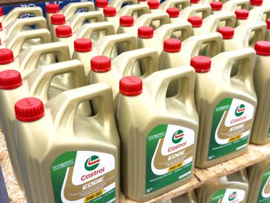 Ponte Nelle Alpi, İtalya - 27 Ocak 2026: Castrol EDGE motor yağı kapları, görünür markalar ve kırmızı kapaklı bir depo ortamında ahşap bir palet üzerinde düzenli olarak düzenlendi