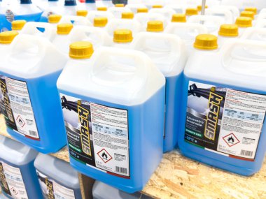 Ponte Nelle Alpi, İtalya - 27 Ocak 2026: Ahşap bir perakende seti üzerinde sarı kapaklı mavi temizlik çözeltisi konteynerleri