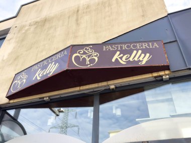 Ponte Nelle Alpi, İtalya - 27 Ocak 2026: Çağdaş bir ortamda bir fırın vitrininde göze çarpan süslü harflerin yer aldığı Pasticceria Kelly tabelası