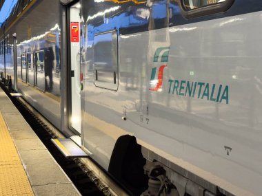 Ponte Nelle Alpi, İtalya - 27 Ocak 2026: Trenitalia treni görünür kapısı ve yansıtıcı yüzeyi olan bir istasyon peronuna park edilmiştir.