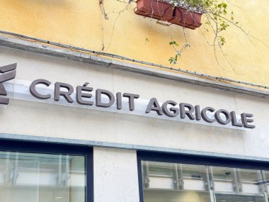 Venedik, İtalya - 17 Şubat 2026: Kredi Agricole banka tabelası girişi üzerinde sarı cephe ve bitkiler bulunan bir binada görülüyor