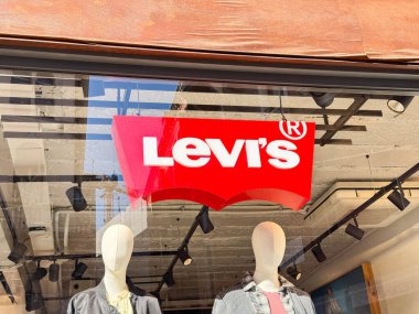 Venedik, İtalya - 17 Şubat 2026: Levi 'nin kırmızı logosu, bir perakende mağazasında sıradan moda sergileyen kot giysileri giyen mankenlerin üzerinde görünür.