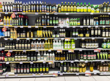 Venedik, İtalya - 14 Şubat 2026: Süpermarket raflarında çeşitli markalar ve ambalaj tasarımları sergilenen çeşitli zeytinyağı şişeleri