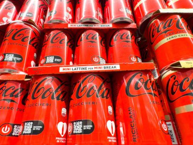 Venedik, İtalya - 14 Şubat 2026: Kırmızı markalı ve İtalyan etiketli istiflenmiş Coca-Cola kutuları, bir mağaza vitrininde kolay erişim için tasarlanmış mini kutular
