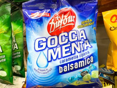 Venedik, İtalya - 14 Şubat 2026: Goccia Menta naneli şeker paketi mavi ile yeşil ve sarı şeker torbaları bir mağazanın rafında görünür