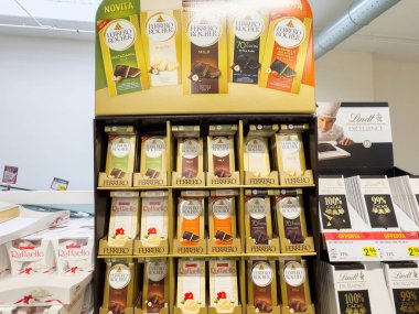 Venedik, İtalya - 14 Şubat 2026: Ferrero Rocher çikolata çeşitleri çeşitli aromalı ve Lindt çikolatalı ürünleri arka planda sergilenmektedir