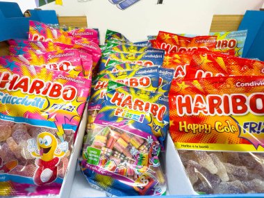 Venedik, İtalya - 14 Şubat 2026: HARIBO şekerleme paketlerinin çeşitli tatlarda sergilenmesi, parlak renkler ve bir perakende ortamında eğlenceli tasarımlar