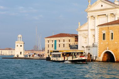 Venedik, İtalya - 07 Şubat 2026: Venedik 'teki tarihi binaların yanında yolcu taşıyan su taksisi, kentin eşsiz mimarisini gözler önüne seriyor.