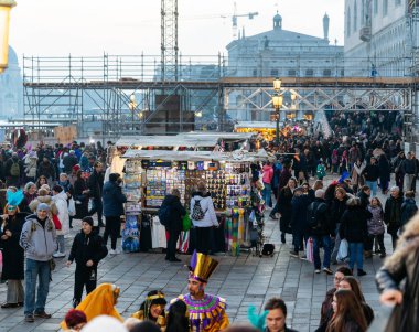 Venedik, İtalya - 07 Şubat 2026: Kalabalık sokak pazarı, çeşitli renkli aksesuarlar ve dekorasyonlar sergileyen bir tezgahtardan alışveriş yapan insanlarla dolu