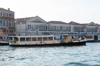 Venedik, İtalya - 07 Şubat 2026: Actv 99 etiketli Vaporetto teknesi Venedik 'teki Büyük Kanal boyunca tarihi mimari ile kıyı boyunca görünür