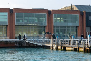 Venedik, İtalya - 07 Şubat 2026: Geniş cam pencereli ve rıhtımlı çağdaş bina