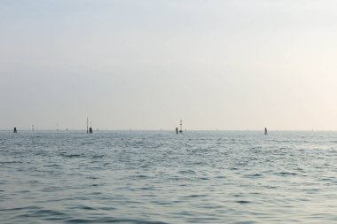 Sakin deniz ufku, bulutlu gökyüzünün altında uzak kutuplar..