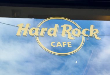 Venedik, İtalya - 10 Şubat 2026: Bulutlu mavi gökyüzüne karşı sarılı Hard Rock Cafe logosu, tanınabilir markayı ve canlı renklerini vurguluyor