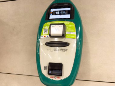 Venedik, İtalya - 10 Şubat 2026: Bir kart okuyucu ve QR kodunun yer aldığı, İtalyanca saat ve talimatları gösteren dijital ekranlı ödeme terminali