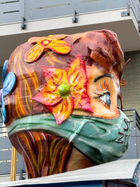 Venedik, İtalya - 12 Mart 2026: Canlı sokak sanat heykeli çiçekli ve maskeli bir kız resmedilmiş, şehir ortamında karmaşık detaylar ve dokular vurgulanıyor