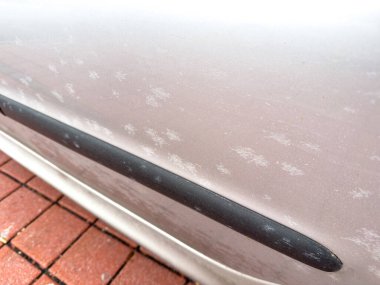 Boya oksitlenmesi ve tuğla yüzeyinde siyah süsleme olan araba kapısı..