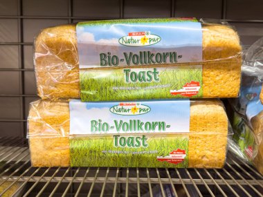 Villach, Avusturya - 29 Ocak 2026: İki somun organik tam tahıllı tost açık bir süpermarket rafında sergilenmektedir.