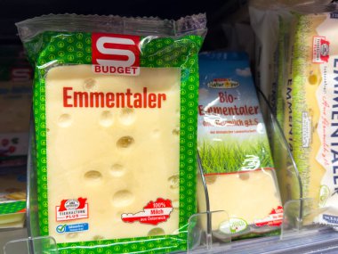 Villach, Avusturya - 29 Ocak 2026: Benzer ürünlerle birlikte süpermarket raflarında S Bütçesi markalaşması ile yeşil ambalajlı Emmental peyniri