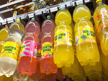 Villach, Avusturya - 29 Ocak 2026: Limon ve greyfurt gibi aromalı Schartner meşrubatları parlak etiketli bir süpermarket rafında düzenlenmiştir.