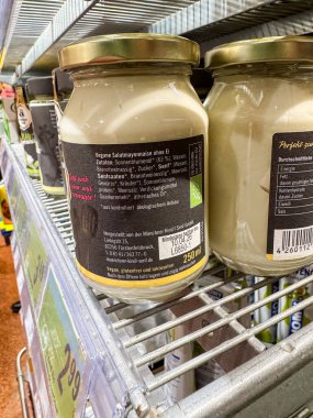 Villach, Avusturya - 29 Ocak 2026: Süpermarket rafındaki kavanozlar dolusu vejetaryen mayonez, içinde malzeme ve beslenme ayrıntıları bulunan etiketler açıkça görülüyor
