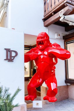 Cortina D Ampezzo, İtalya - 07 Mart 2026: Çağdaş sanat ve tasarım unsurlarını vurgulayan bir butiğin girişine yerleştirilmiş büyük kırmızı goril heykeli