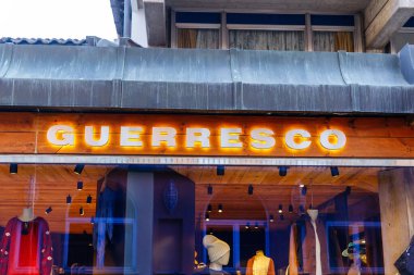 Cortina D Ampezzo, İtalya - 07 Mart 2026: GUERRESCO mağazasının önü, bir perakende seti içinde aydınlık bir tabela altında kış giysisi ve aksesuarları sergiliyor