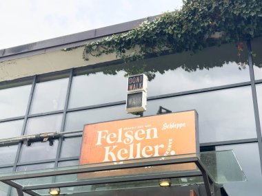 Villach, Avusturya - 10 Mart 2026: Yaya trafiğinin altında görülen Felsen Keller Restoran tabelası bir kentte 