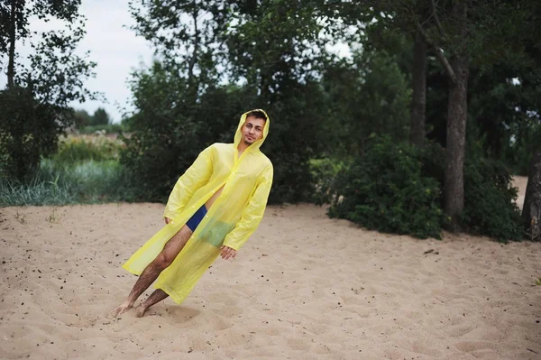 Πέφτει ο άνθρωπος σε κίτρινα αδιάβροχα ανάρπαστος από τον άνεμο — Φωτογραφία Αρχείου