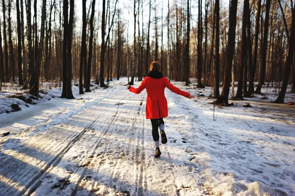 Regocijándose mujer feliz en movimiento volador lleno de alegría y vitalidad corriendo a través del bosque de primavera en la puesta del sol . — Foto de Stock