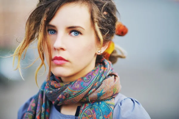 Gorgeous portrait of a young serious girl with beautiful blue eyes and youthful hair in the scarf   color picture, closeup. — Stock Photo, Image