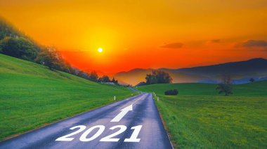 Boş asfalt yol ve yeni yıl 2021 kavramı. 2021 'e kadar dağlarda güneşe karşı boş yol golleri atmak ve geride eski yılları bırakmak. Büyüme başarısı kavramı, zaman geçirmek için gelecek