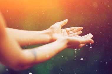 hand catching rain drops on blurred background. Woman hands praying for blessing from god on sunset. Empowerment, sacred forgiveness, positive arm energy, good morning, reborn change calm zen concept. clipart