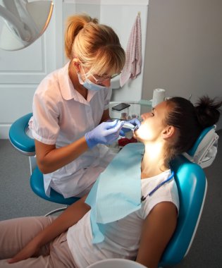 Güzel kadın dişçi bir hastanın diş diş ofiste tedavi