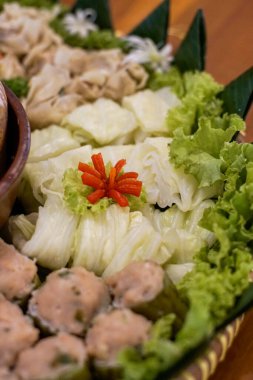 Muz yaprakları üzerinde servis edilen haşlanmış lahana, marul ve biber garnitürlü geleneksel Endonezya sebze tabağı..